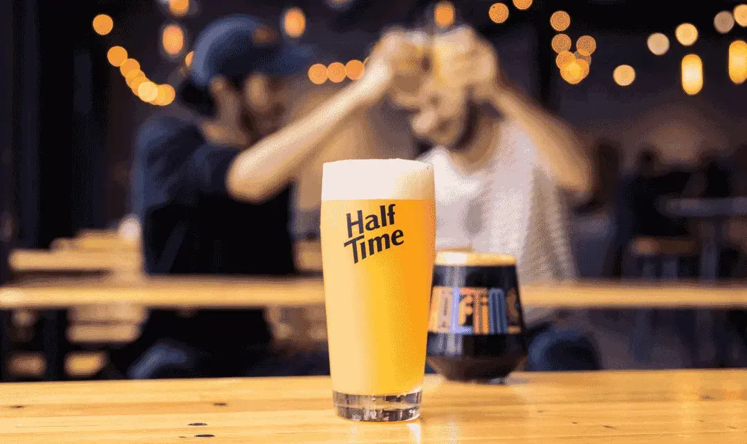 A pint of beer on a bar in a Half Time glass