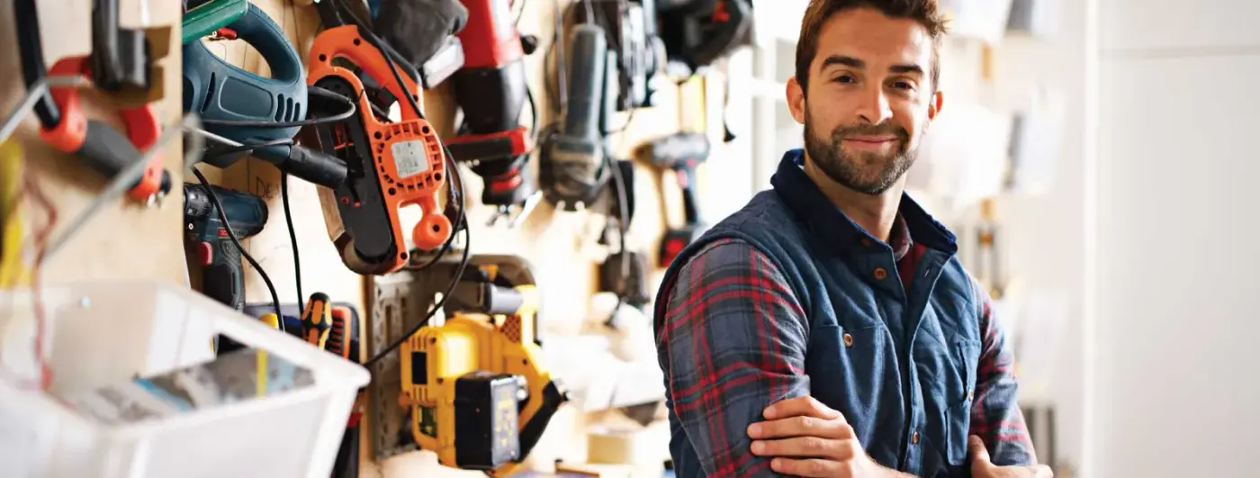 A contractor in front of a wall of power tools